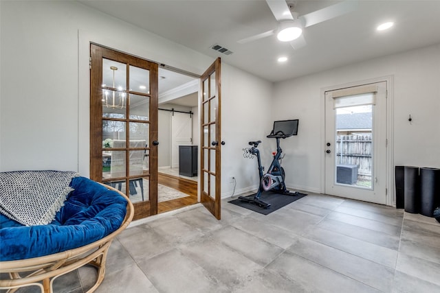 exercise area featuring french doors, ceiling fan, and a barn door