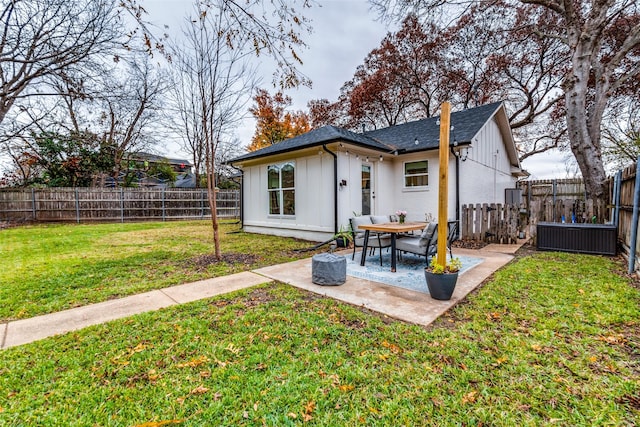 back of property with a yard and central AC unit