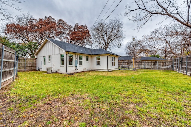 back of property with cooling unit and a lawn