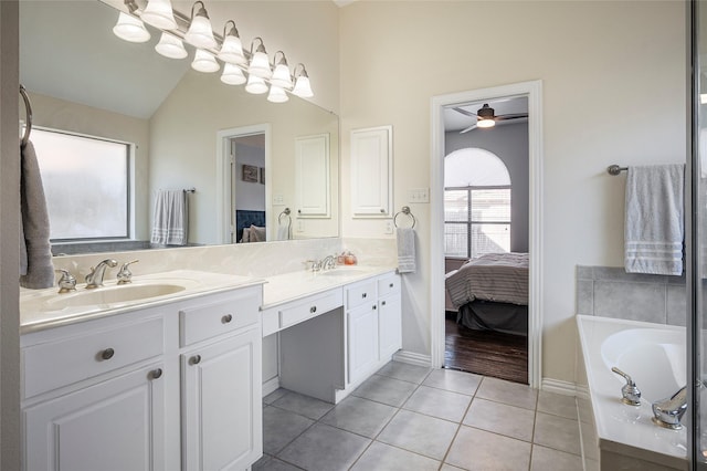 bathroom featuring vanity, a bath, tile patterned floors, vaulted ceiling, and ceiling fan