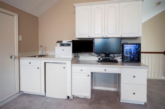 unfurnished office with light colored carpet, sink, and vaulted ceiling