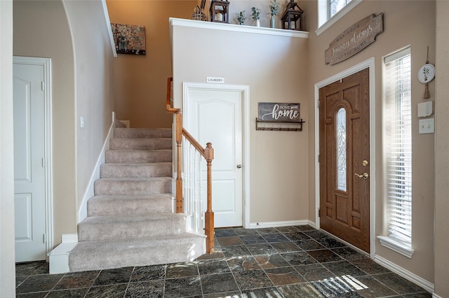 entrance foyer featuring a healthy amount of sunlight and a towering ceiling