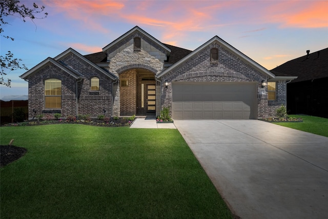 view of front of house with a garage and a lawn