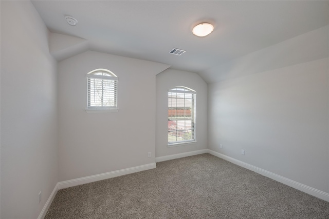 carpeted empty room featuring lofted ceiling