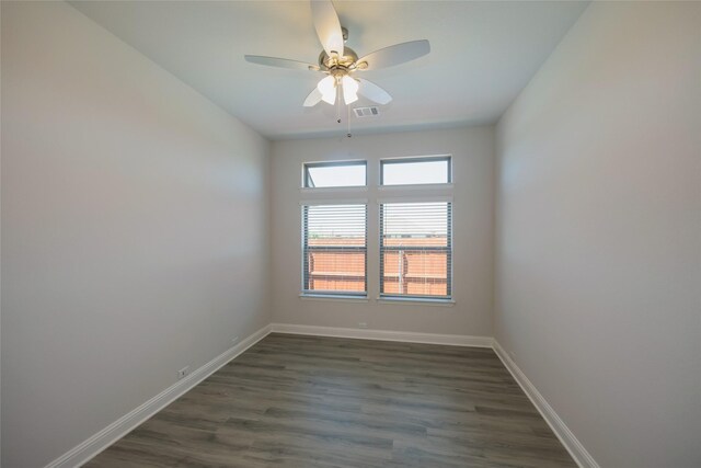 spare room with dark wood-type flooring and ceiling fan