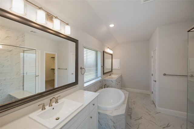 bathroom featuring a relaxing tiled tub, lofted ceiling, and vanity