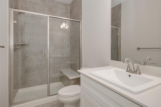 bathroom featuring vanity, toilet, tile patterned flooring, and a shower with door