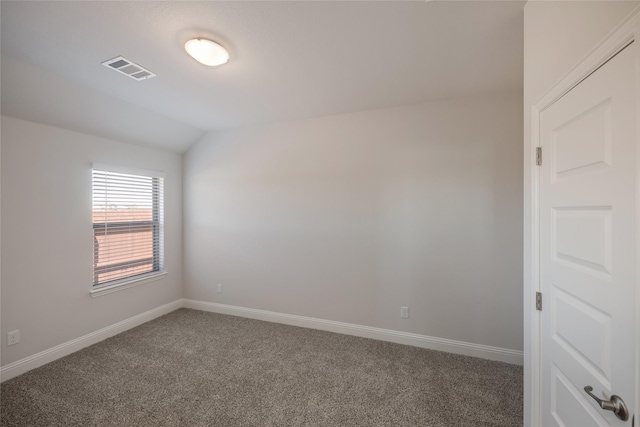 empty room featuring dark colored carpet and vaulted ceiling