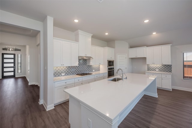 kitchen featuring white cabinets, stainless steel appliances, a kitchen island with sink, and sink