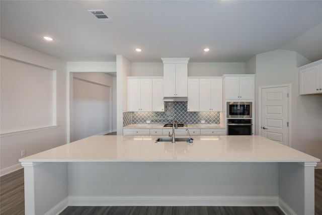 kitchen featuring oven and a large island with sink