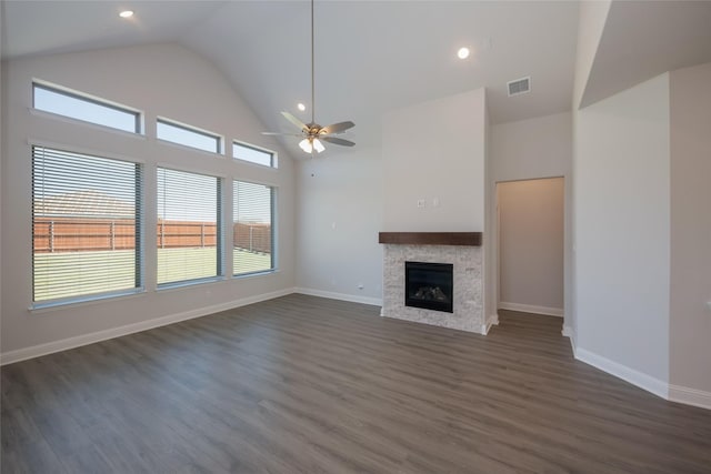 unfurnished living room with ceiling fan, dark hardwood / wood-style flooring, and a towering ceiling