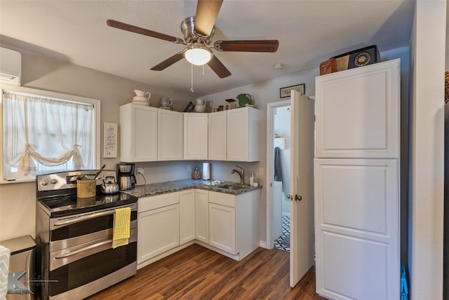 kitchen featuring range with two ovens, dark stone counters, dark hardwood / wood-style floors, sink, and white cabinetry