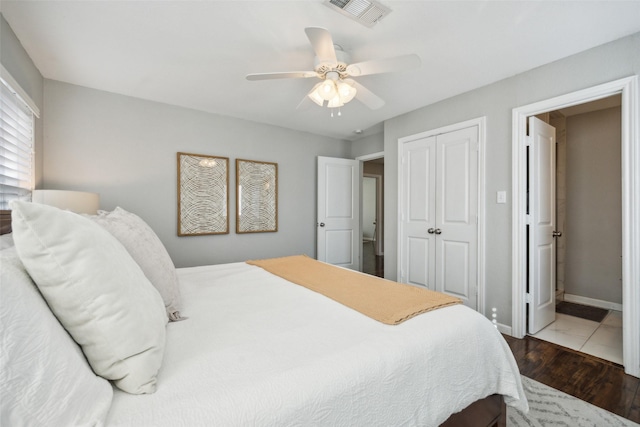 bedroom with dark wood-type flooring, a closet, and ceiling fan