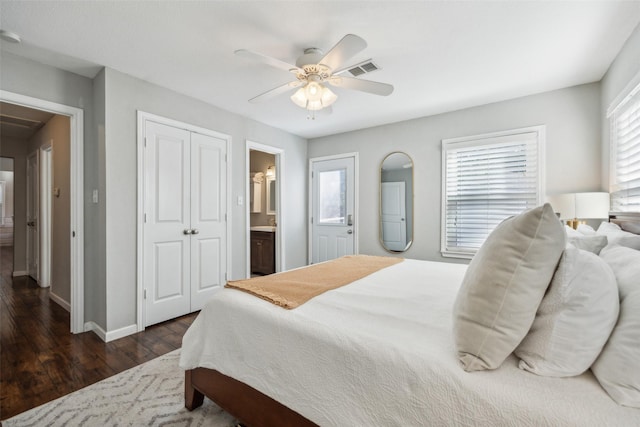 bedroom featuring multiple windows, dark hardwood / wood-style floors, ceiling fan, and a closet