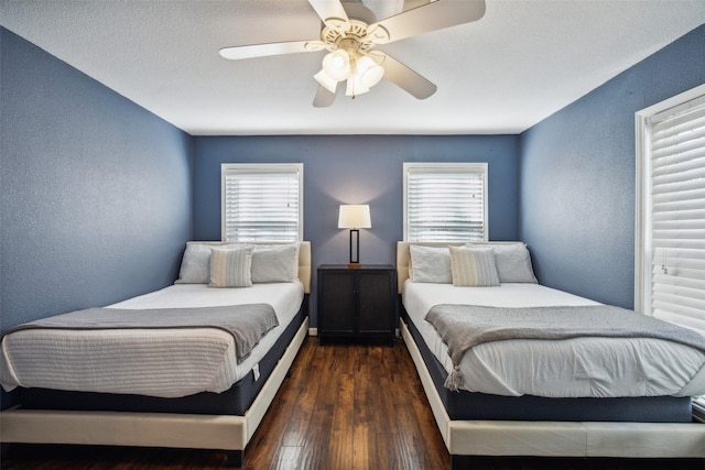 bedroom with ceiling fan, dark hardwood / wood-style floors, and multiple windows