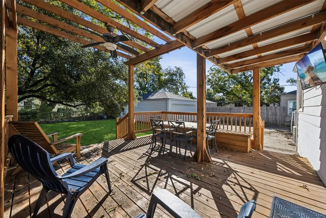 deck featuring ceiling fan and a lawn