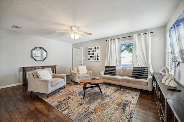 living room featuring dark hardwood / wood-style flooring, a textured ceiling, and ceiling fan