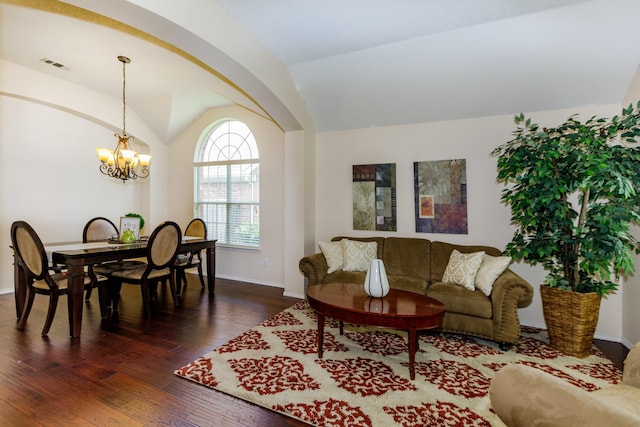 living room featuring a chandelier, vaulted ceiling, and dark wood-type flooring