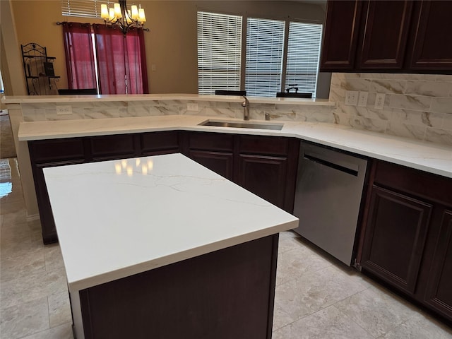 kitchen with decorative backsplash, stainless steel dishwasher, sink, pendant lighting, and a notable chandelier