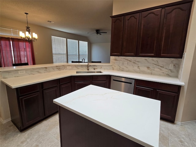 kitchen with ceiling fan with notable chandelier, sink, hanging light fixtures, stainless steel dishwasher, and kitchen peninsula