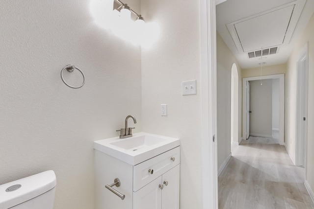 bathroom with vanity, hardwood / wood-style flooring, and toilet