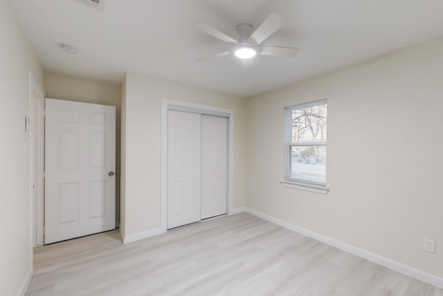 unfurnished bedroom with light wood-type flooring, a closet, and ceiling fan