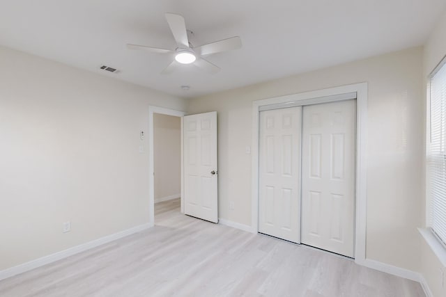 unfurnished bedroom with ceiling fan, a closet, and light wood-type flooring