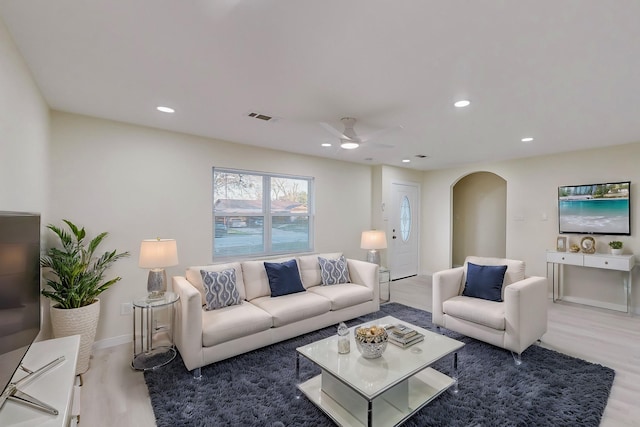 living room with wood-type flooring and ceiling fan