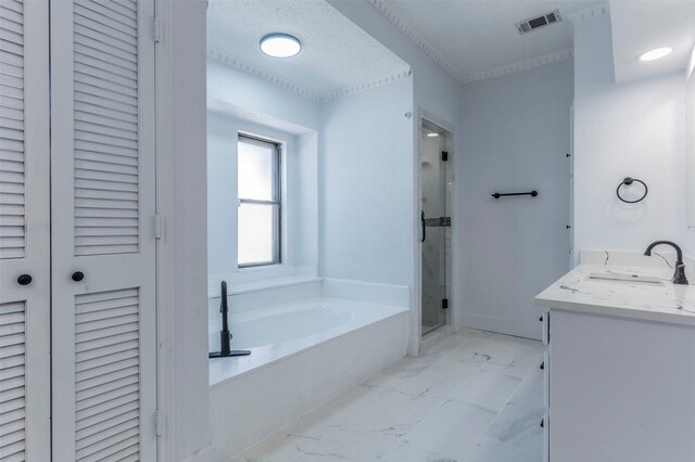 bathroom featuring vanity, independent shower and bath, and a textured ceiling