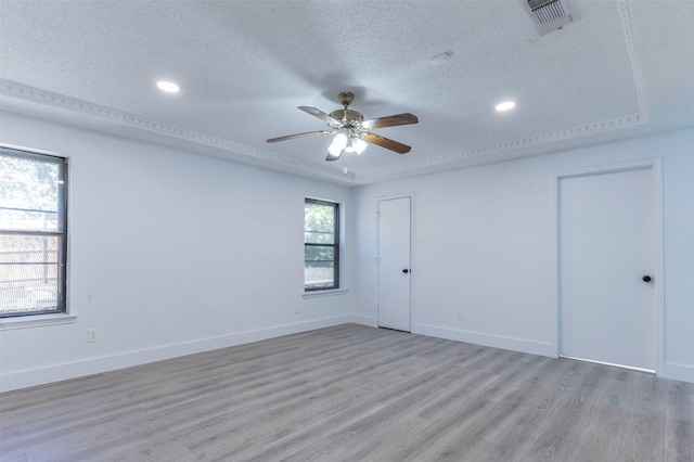 empty room with ceiling fan, light wood-type flooring, and a textured ceiling