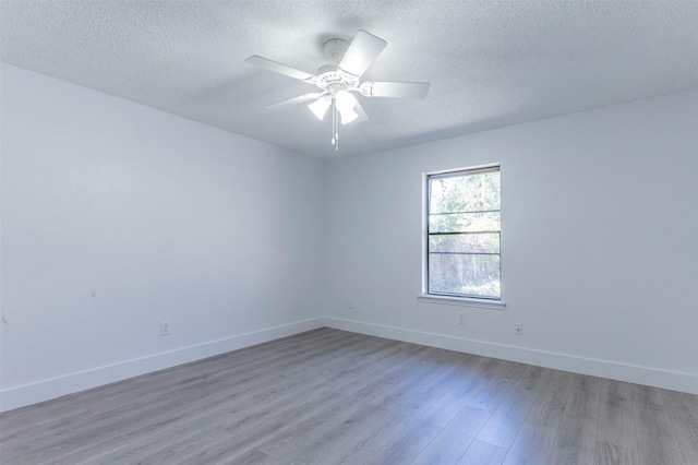 empty room with ceiling fan, light hardwood / wood-style floors, and a textured ceiling