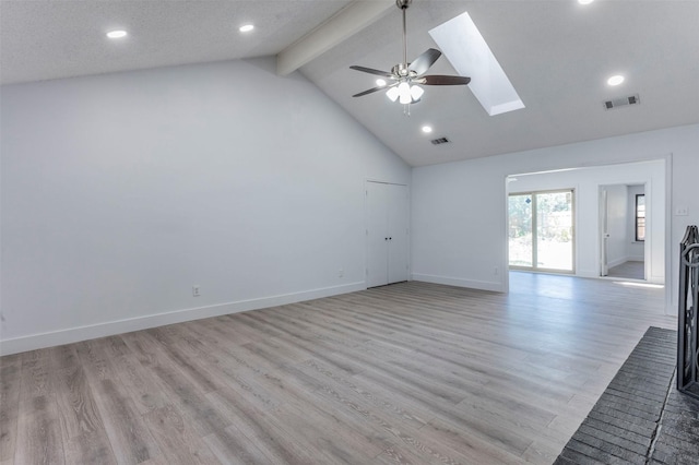 unfurnished living room featuring light wood-type flooring, a skylight, ceiling fan, beam ceiling, and high vaulted ceiling