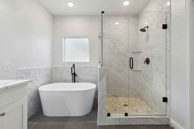 full bath featuring a soaking tub, tile patterned flooring, vanity, a shower stall, and tile walls