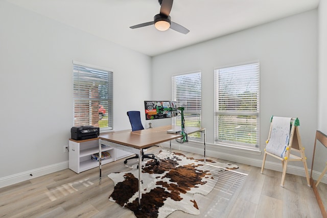 office area featuring a healthy amount of sunlight, light wood-style floors, and baseboards