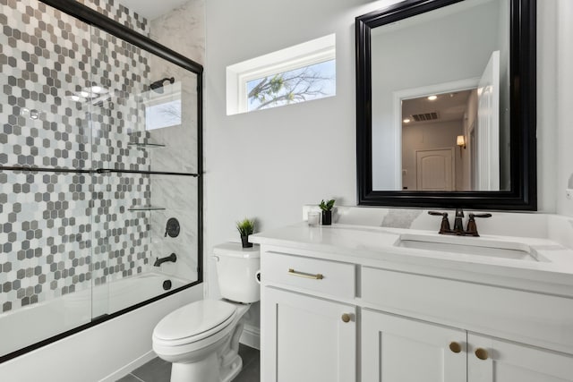 full bathroom featuring toilet, vanity, and bath / shower combo with glass door