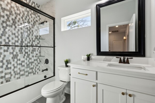 full bath featuring enclosed tub / shower combo, visible vents, vanity, and toilet