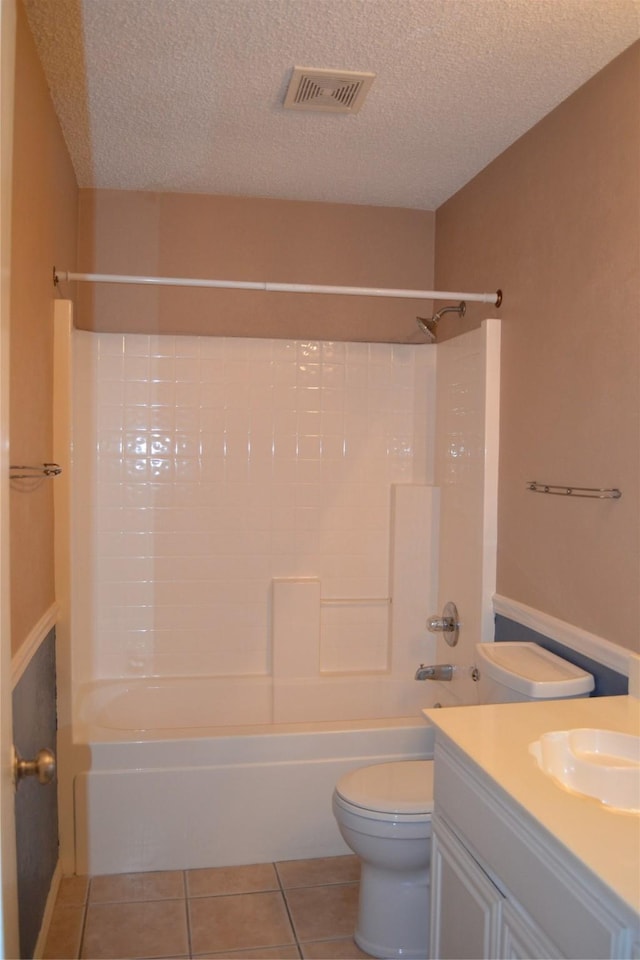 full bathroom featuring vanity, bathtub / shower combination, tile patterned flooring, toilet, and a textured ceiling