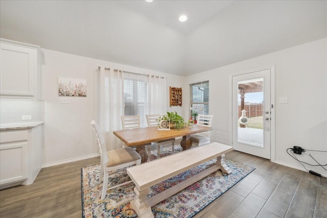 dining space featuring wood-type flooring, high vaulted ceiling, and a healthy amount of sunlight