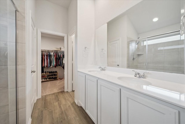 bathroom with hardwood / wood-style floors, vanity, and a shower with door