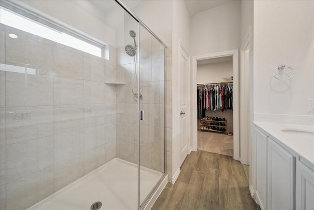 bathroom featuring vanity, wood-type flooring, and walk in shower