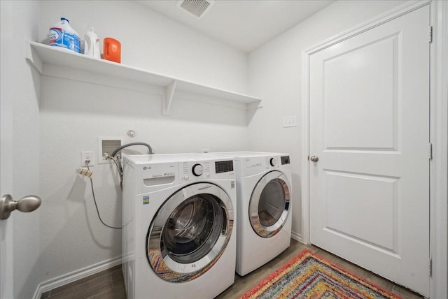 laundry room with independent washer and dryer and hardwood / wood-style floors