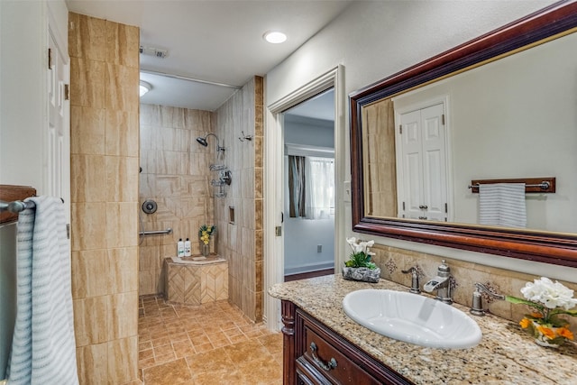 bathroom with vanity and a tile shower