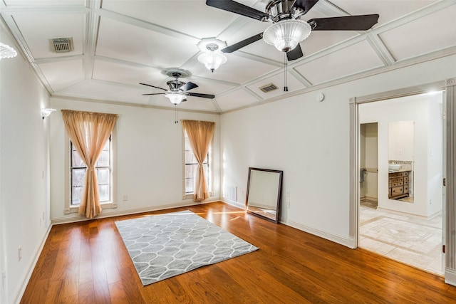 empty room featuring ceiling fan, hardwood / wood-style floors, coffered ceiling, and ornamental molding