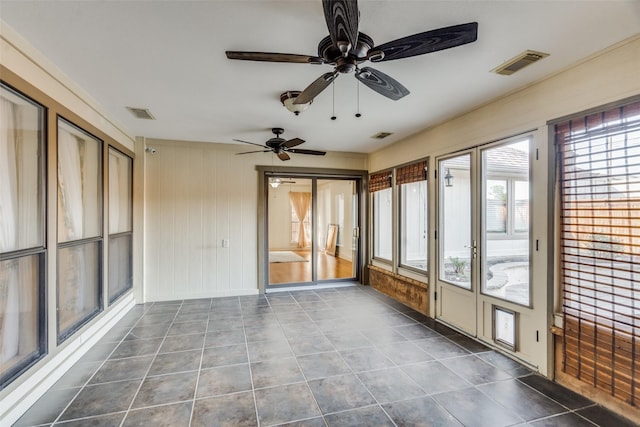 unfurnished sunroom featuring ceiling fan