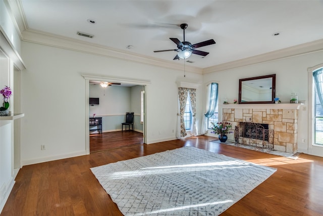 living room featuring crown molding, ceiling fan, a fireplace, and hardwood / wood-style floors