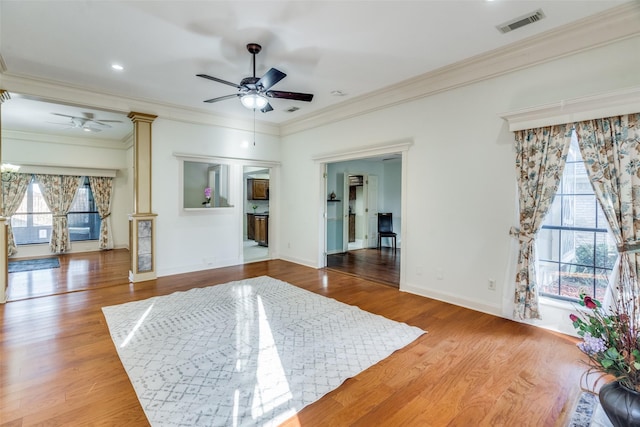 bedroom featuring hardwood / wood-style flooring, ceiling fan, ornamental molding, and ornate columns