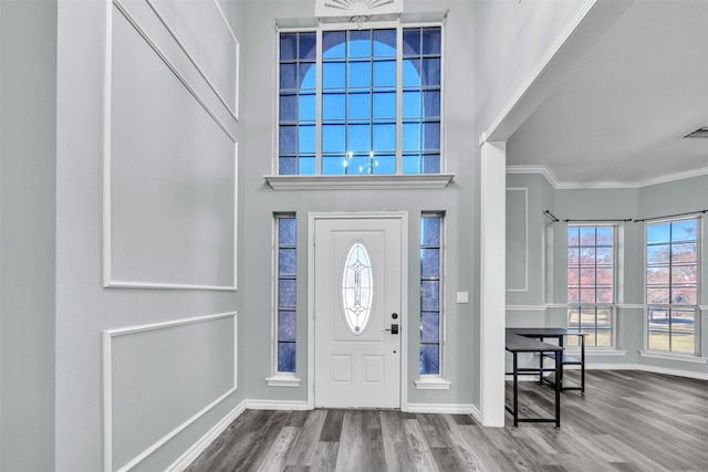 foyer entrance with ornamental molding and hardwood / wood-style flooring