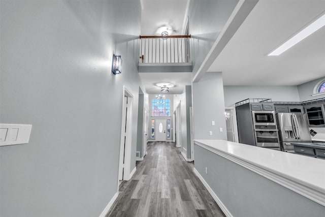 hallway with a high ceiling and dark wood-type flooring