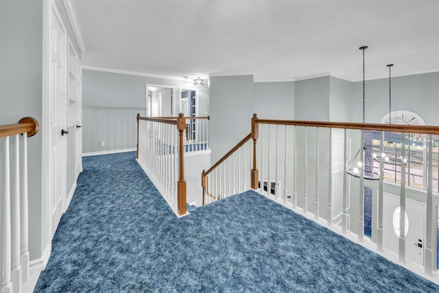 corridor featuring dark carpet, crown molding, and a notable chandelier