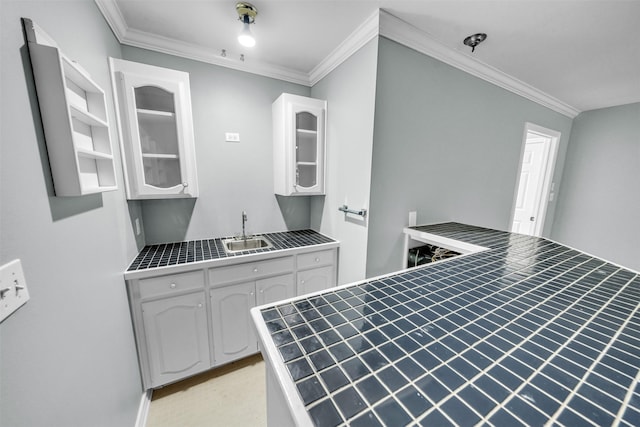 kitchen featuring white cabinetry, ornamental molding, and sink